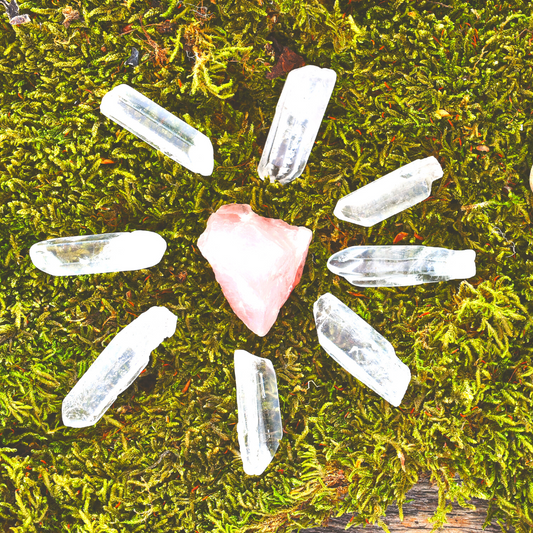 clear quartz and rose quartz crystal grid on grass